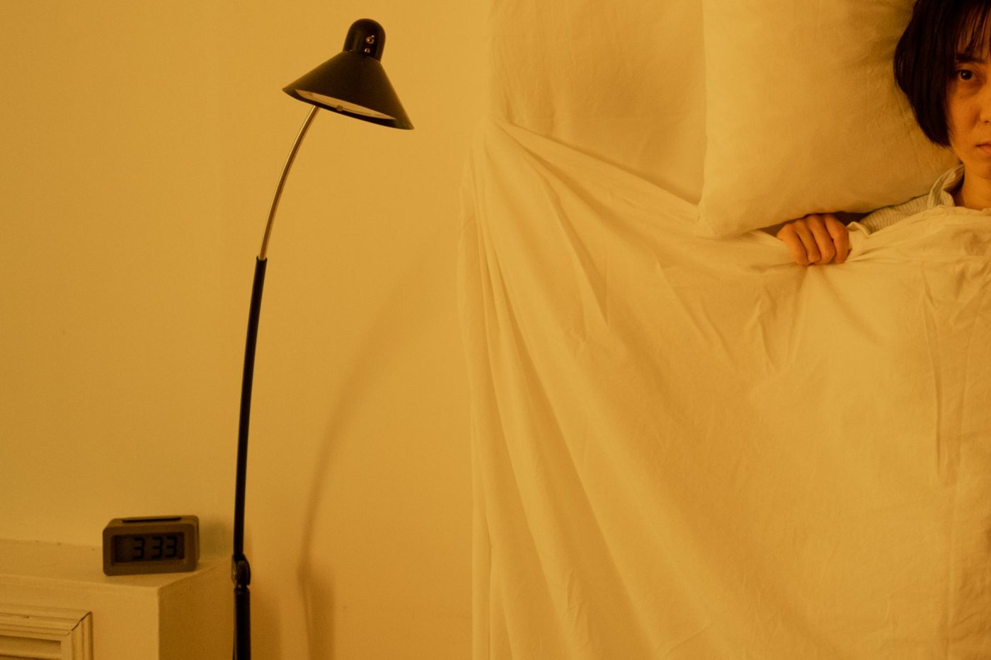 A woman peeking at the clock at night