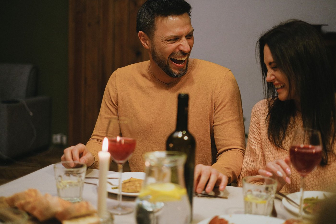 A couple laughing together at dinner